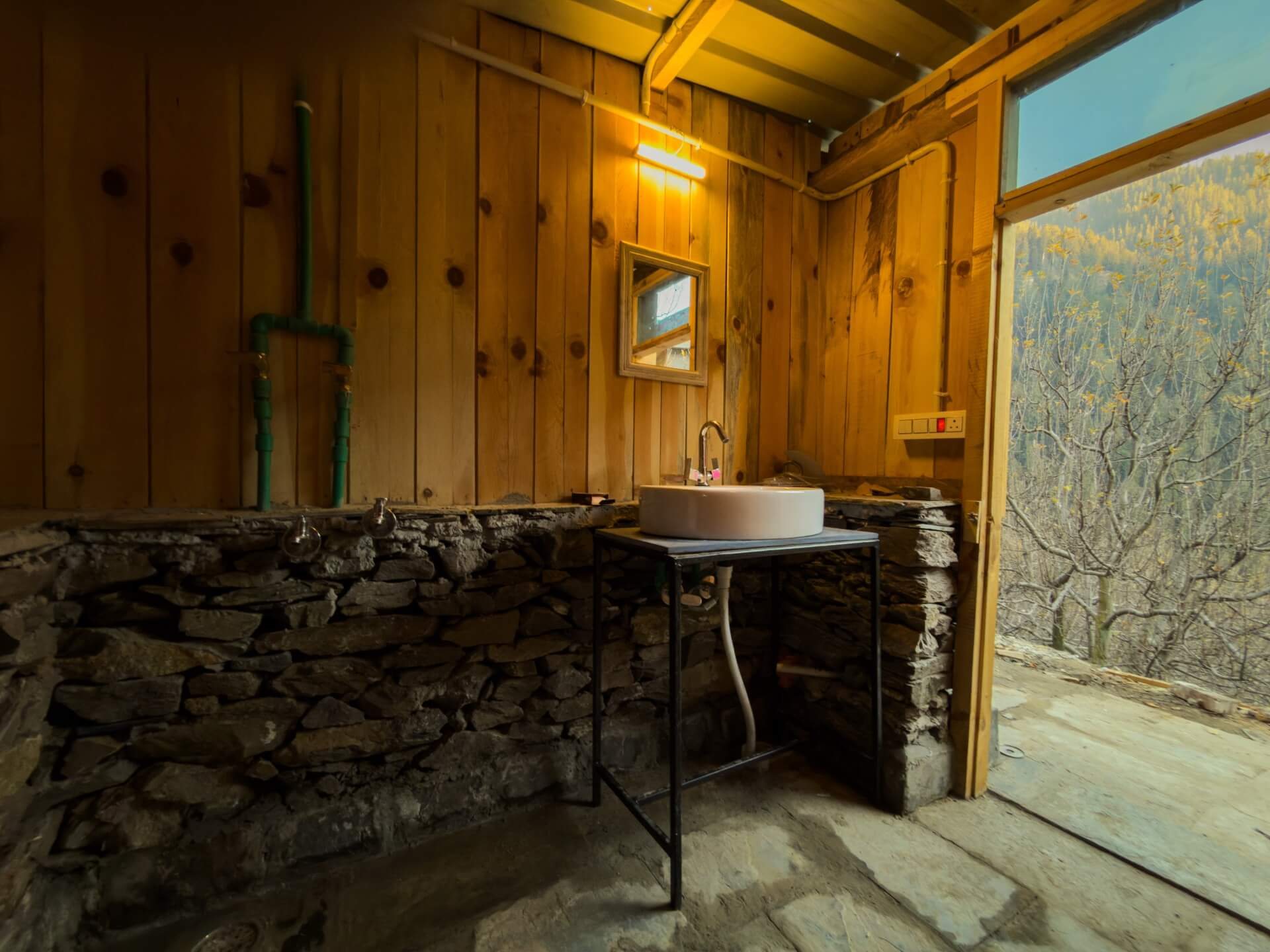 A handcrafted stone-and-timber washroom at Wild, open to the forest